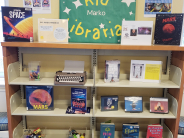 A children's book display with books about space, interactive items, and posters about dyslexia.
