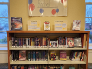 Bookshelves full of books with a poster above