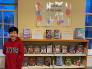 Bryson standing next to his Kid Librarian display