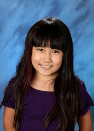 A school picture of a young girl with bangs and long dark hair