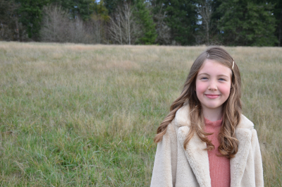 A girl standing out in a field. 