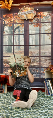 Picture of a girl holding a book on a daybed