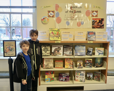 Ollie and Adam standing next to their Kid Librarian display