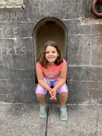Samantha sitting in an outdoor stone alcove